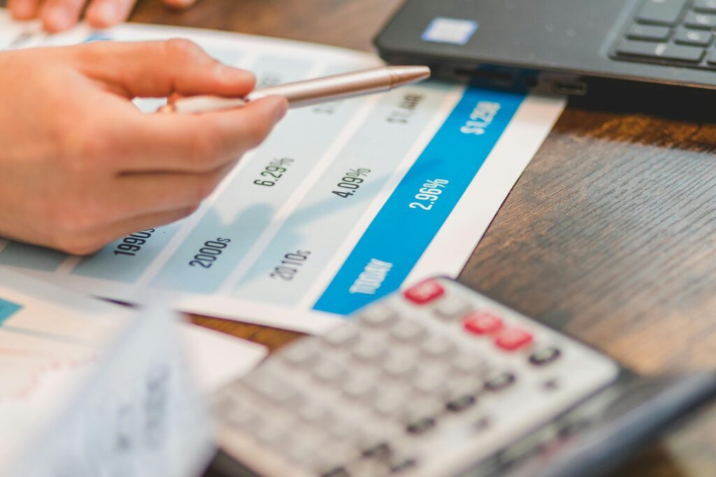 A person working with a calculator and a paper with a pen in their hand.
